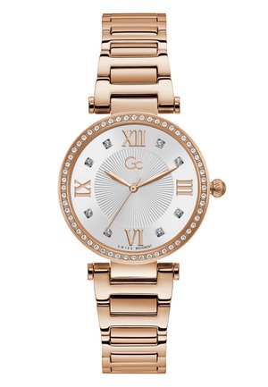 Orologio in oro rosa con cassa tonda, quadrante argentato, numeri romani e accenti in cristallo. Bracciale a maglie in metallo con finitura lucida.