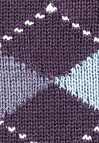 Dzianina z geometrycznym wzorem w kolorze purpurowym, niebieskim i białym, o gładkiej fakturze i wyraźnych falach w całym wzorze.