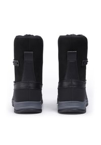 Mustat nilkkurit, joissa on mokkasametti, silkkiset nahkaosuudet, pyöreä kärki ja harmaat kumipohjat. Varustettu nappi- ja hihnadetaileilla.