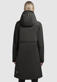 Lång svart vattentät kappa med huva, med en elegant design, slät textur och en logotyp på baksidan. Visad från bakvyn.