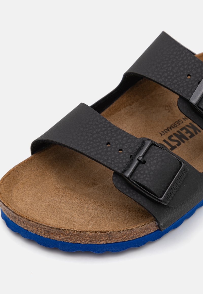 Sandalo nero con due cinturini in materiale sintetico testurizzato, fondello in sughero e suola in gomma blu. Presenta fibbie metalliche regolabili per una vestibilità personalizzata.