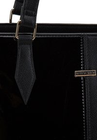 Sorte patentlæder håndtaske med teksturerede læderremme og guld "WITTCHEN" mærkeskilt på fronten.