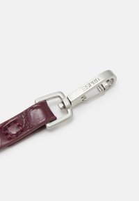 Bracelet en cuir marron à finition texturée, avec un clip en métal argenté portant le nom de la marque "ESPRIT" gravé.