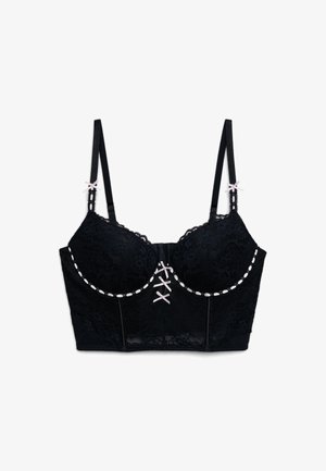 Reggiseno lungo in pizzo nero con sottili spalline regolabili, dettagli di fiocchi rosa chiaro sulle spalline e sul davanti, e decorazioni con nastro rosa lungo le coppe.