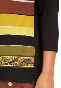 Un haut multicolore avec des rayures horizontales marron, jaune et verte, agrémenté d'un motif en bas. Fabriqué en tissu doux.