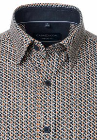 Bequeme Passform-Shirt mit einem geometrischen Muster in Orange, Weiß und Schwarz. Verfügt über einen Button-Down-Kragen und kontrastierender innerer Stofftextur.