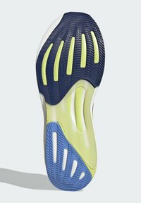 Suela de zapatilla de correr con acentos en azul marino, azul claro y amarillo neón. Goma texturizada para agarre, con surcos flexibles y canales de drenaje.