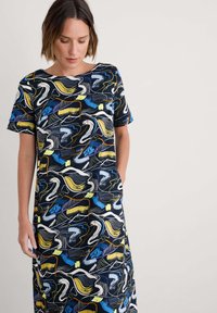 Rochie cu mânecă scurtă, având un fond bleu închis și un model abstract multicolor. Confecționată dintr-un material moale, cu o croială lejeră și buzunare.