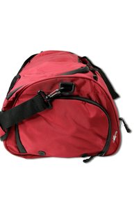 Rode stoffen sporttas met zwarte accenten, voorzien van een schouderriem, ritssluiting en externe zakken. Gestructureerd oppervlak met hardware details.