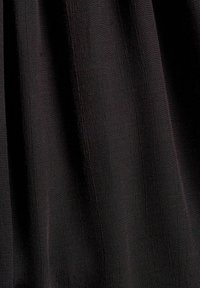 Tissu noir texturé avec des lignes verticales subtiles. Le matériau semble léger et légèrement brillant, avec une surface lisse.