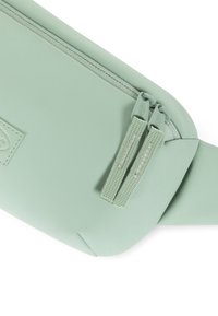 Marsupio di colore verde menta realizzato in materiale silicone liscio, dotato di chiusura con zip e due tiranti in tessuto per un'apertura facile.