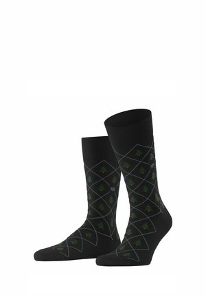 Chaussettes noires avec un motif en losanges featuring des arbres verts et des accents rouges. Fabriquées à partir d'un matériau doux avec des poignets côtelés et une texture lisse.