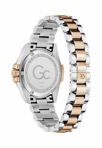 Dwutonowa stalowa zegarka posiada srebrny bransoletkę z złotymi akcentami oraz okrągłą kopertę. Tył jest wypolerowany z wygrawerowanym logo marki.