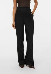 Pantalons noirs taille haute avec une coupe droite, dotés de poches latérales et d'une texture de tissu lisse et brillant.