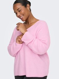 Pink knitted sweater with a loose fit, V-neck design, and ribbed texture. Features dropped shoulders and long sleeves.