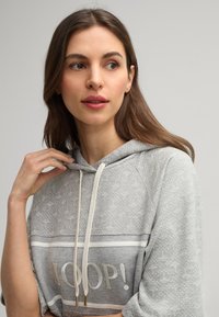 Grau sweatshirt mit Kapuze und weißen Akzenten, ausgestattet mit einem gemusterten Design, Kordelzügen und dem Schriftzug "YOOP!" in fetter Schrift auf der Vorderseite.
