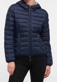 Navyblaue Steppjacke mit Kapuze, ausgestattet mit einem Reißverschluss vorne, zwei Seitentaschen und einem gesteppten Design mit horizontalen Nähten.