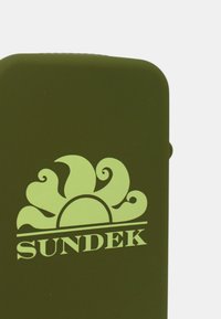 Custodia in silicone verde con un logo prominente di colore verde chiaro che rappresenta un design a raggiera con accenti ondulati; texture liscia e forma rettangolare.