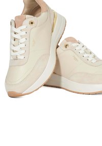 Baskets beiges avec un mélange de cuir lisse et de textures en daim, des lacets blancs, des accents dorés et une semelle rembourrée.