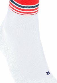 Chaussette blanche à cheville avec des rayures rouges et bleues en haut et un petit "R" bleu près de la zone des orteils.