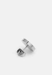 Cercei rotunzi argintii cu finisaj neted, având un sistem de prindere tip fluture și o textură lustruită. Design simplu și minimalistic.