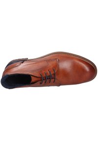 Scarpa di pelle marrone con finitura liscia, punta rotonda e sei asole. I lacci sono scuri e l'interno presenta una morbida foderatura scura.