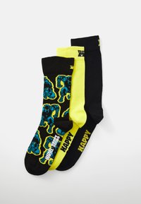 Three pairs of socks: black with blue pattern, bright yellow, and solid black featuring yellow text. Cotton material, medium length.