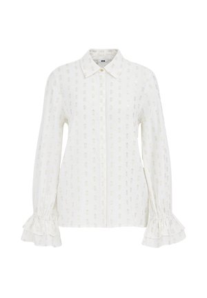 Blusa bianca a maniche lunghe con colletto, tessuto strutturato, sottili motivi metallici e polsini arricciati.