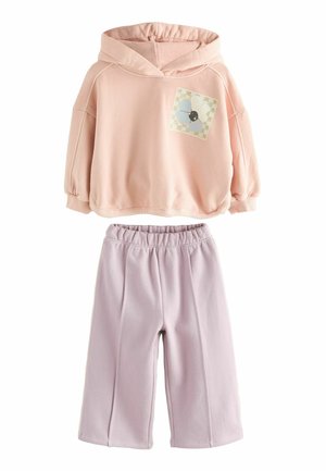 Persikofärgad hoodie med en rutmönstrad blommig applikation, ihopparad med ljuslila vida sweatpants. Mjuk, avslappnad tyg; elastisk midja på byxorna.