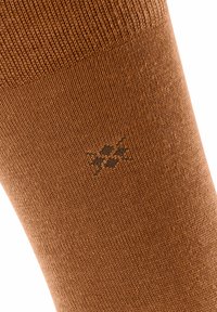 Calze marroni in tessuto lavorato a maglia con una finitura testurizzata, con un piccolo motivo del logo scuro vicino all'area della caviglia.
