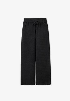 Black wide-leg pants made of textured fabric. Features an elastic waistband with a drawstring closure. Straight, floor-length cut.