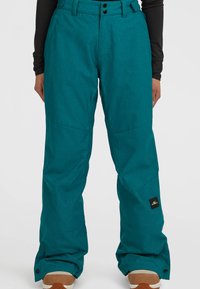 Teal snöbyxor gjorda av hållbart tyg, med en avslappnad passform, tv�å framknappar och ett logomärke på vänster ben.