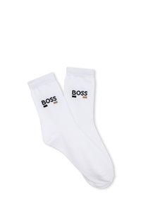 Calzini bianchi in cotone con polsini a coste e ricamo del logo "BOSS" in nero e beige. Texture liscia con design fino a metà polpaccio.