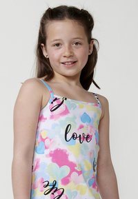 Leichtes Tanktop mit einem bunten Herzmuster in Pink, Blau und Gelb, dazu schwarzer Text mit der Aufschrift "love". Dünne Träger und weicher Stoff.