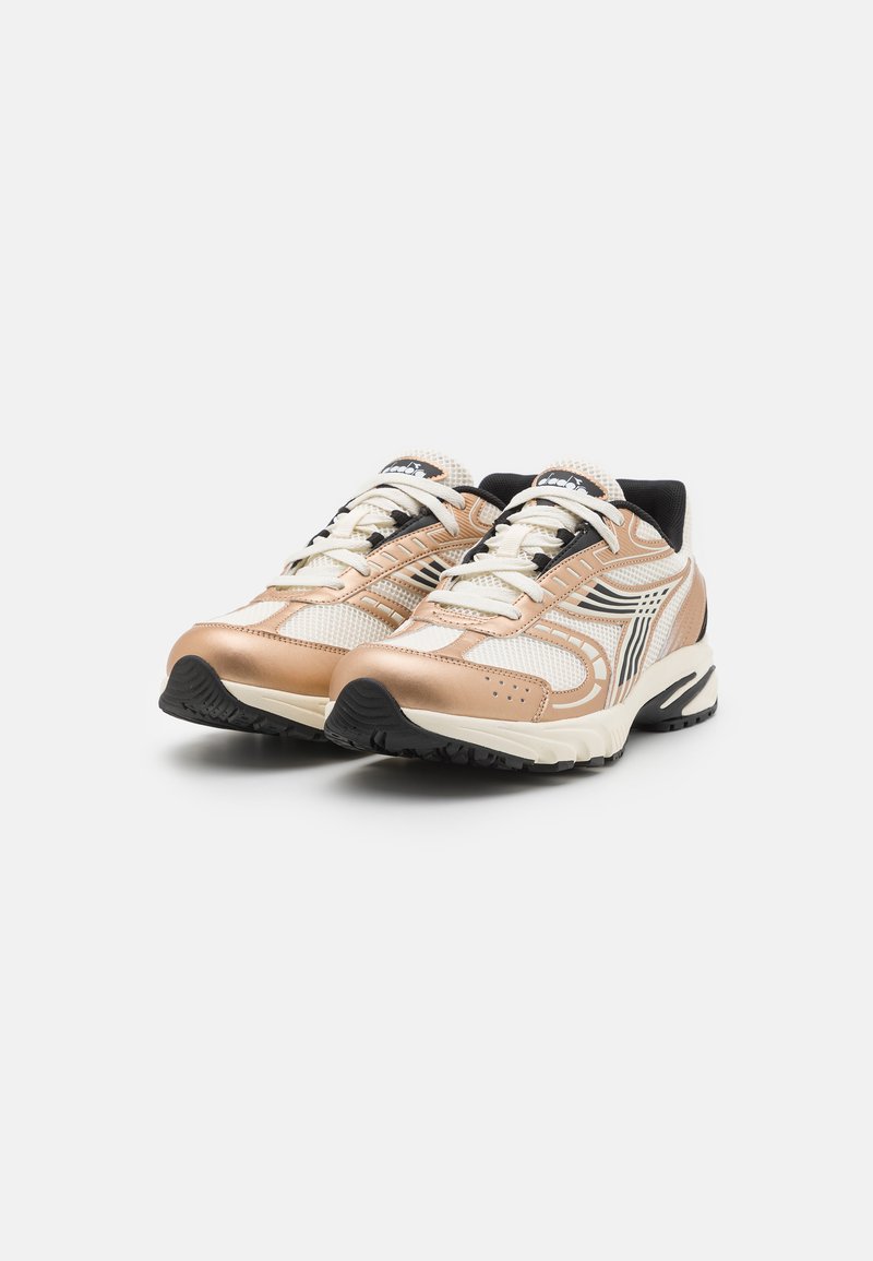 Zilveren en beige sportschoenen met een bovenwerk van mesh, zwarte accenten en een gestructureerde rubberen zool. Voorzien van witte veters en een logo op de tong.