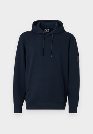 Navy blue hoodie made from cotton blend, featuring a front pocket, adjustable drawstring hood, and textured logo patch on the sleeve.
