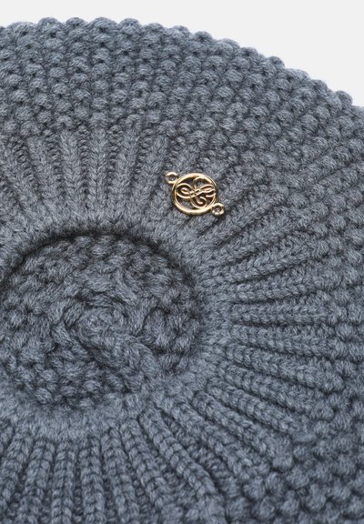 Béret tricoté gris foncé avec motif côtelé et une petite épingle décorative dorée circulaire attachée près du centre.