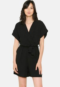 Czarny kombinezon z krótkim rękawem, z głębokim dekoltem w kształcie V, zapinany w talii paskiem i wykonany z przewiewnego materiału, zapewniający luźny krój.