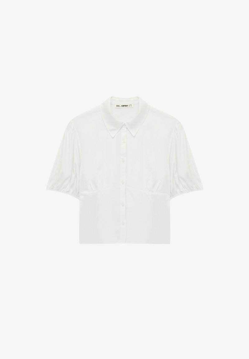 Blouse blanche à manches courtes avec un col pointu, patte de boutonnage devant et plis froncés subtils aux épaules et à la poitrine.