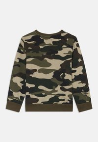Camo-mønsteret gensere i nyanser av grønn, brun og beige; har ribbestrikkede ermer og avslutning, rund hals og myk tekstur.