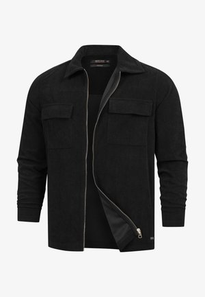 Giacca camicia in cotone a coste nera con colletto a punte, chiusura con zip frontale, due tasche sul petto e texture a coste.