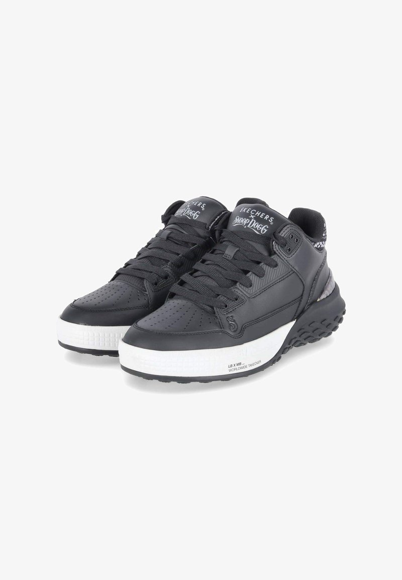 Baskets de sport noires en cuir et en maille, avec une semelle texturée blanche, un bout rond et un branding bien visible sur la languette.