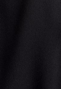 Schwarzer Stoff mit einer glatten, leicht strukturierten Oberfläche. Das Material weist ein dichtes Gewebe, eine gleichmäßige Farbe und keine sichtbaren Muster oder Akzente auf.