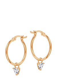 Złote kolczyki w formie kół z gładkim wykończeniem, z sercowym kryształowym zawieszeniem w przejrzystym kolorze zwisającym z każdego kolczyka.