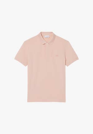 Koszulka polo z miękkiej bawełnianej tkaniny w delikatnym różowym kolorze. Posiada kołnierzyk, rozcięcie zapinane na dwa guziki oraz haftowane logo na piersi. Krótkie rękawy.