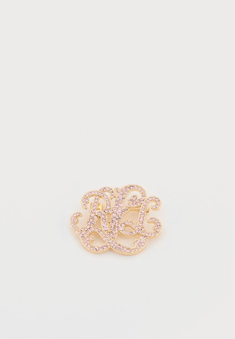 Broš s zlatnim tonom s isprepletenim slovima, ukrašen malim ružičastim rhinestones. Glatka metalna površina s delikatnim oblikovanim dizajnom.