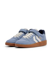 Blauwe suède sneakers met witte strepen, crèmewitte veters, klittenbandsluiting en een zool van gumrubber, uitgevoerd in een laag profiel ontwerp.