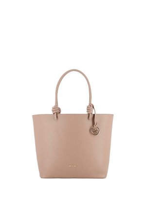 Bolso tote de cuero beige con dos asas anudadas y un colgante redondo dorado colgado en el asa derecha.