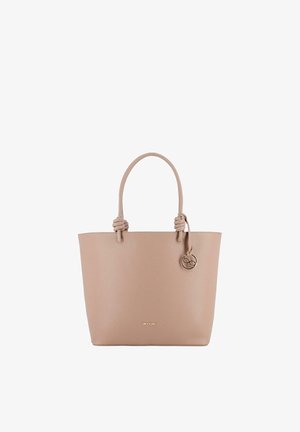 Bolso tote de cuero beige con dos asas anudadas y un colgante redondo dorado colgado en el asa derecha.