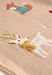 Bestickter Stoff mit einem beigen Hintergrund, auf dem ein weißes Rentier mit einem Schal, ein brauner Fuchs und goldene Sterne abgebildet sind, alles in sanften Texturen.